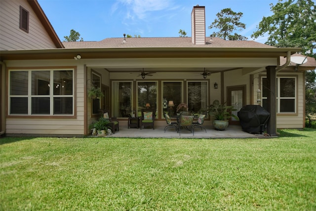 rear view of property featuring a patio, a yard, and ceiling fan