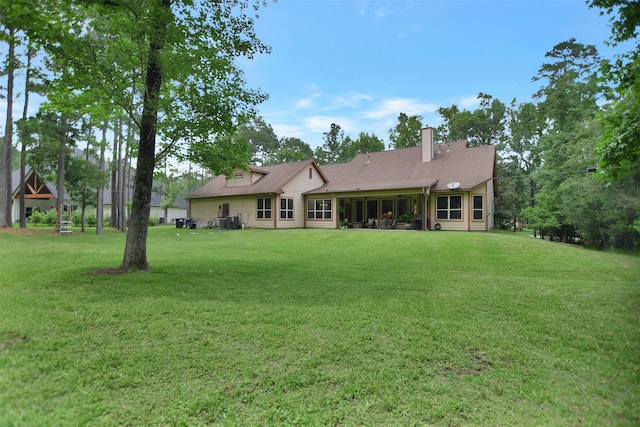 rear view of house with a yard and central AC unit