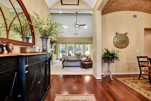 entryway featuring dark wood-type flooring, high vaulted ceiling, and ceiling fan