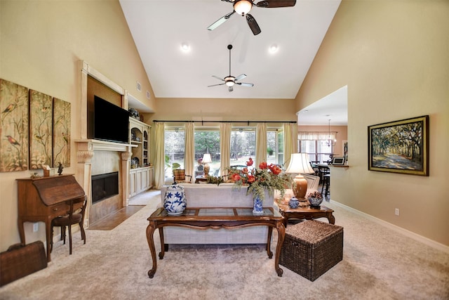 carpeted living room with a healthy amount of sunlight, ceiling fan, and high vaulted ceiling