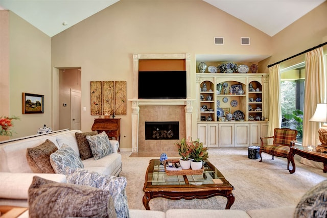 living room with light carpet, high vaulted ceiling, and a tile fireplace