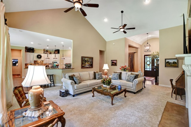 living room with ceiling fan, high vaulted ceiling, and light carpet