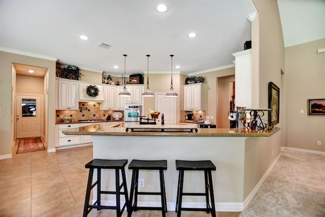 kitchen featuring stone counters, pendant lighting, kitchen peninsula, and a kitchen breakfast bar