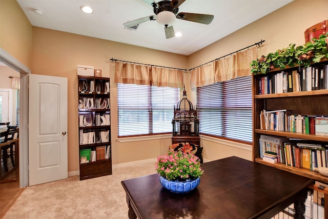 carpeted home office featuring ceiling fan