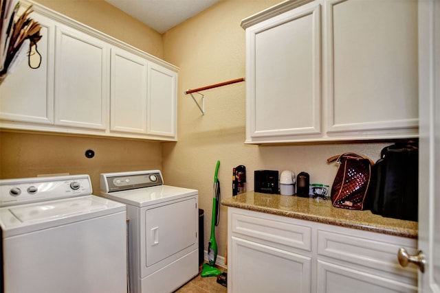 laundry room featuring washer and clothes dryer and cabinets