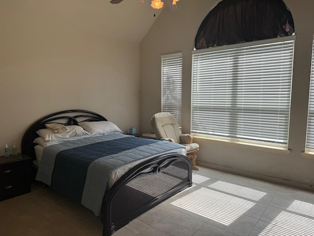 tiled bedroom with ceiling fan and lofted ceiling