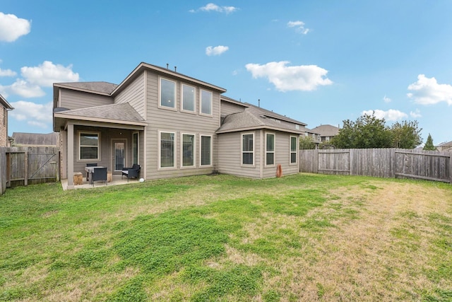 rear view of house with a lawn and a patio