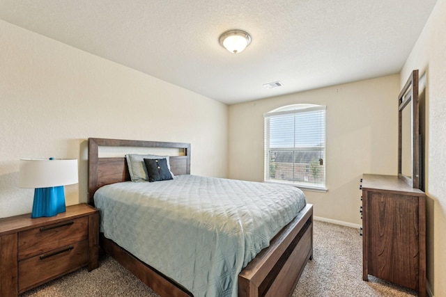 bedroom with light carpet and a textured ceiling