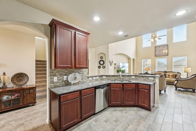 kitchen featuring sink, stone countertops, backsplash, kitchen peninsula, and stainless steel dishwasher