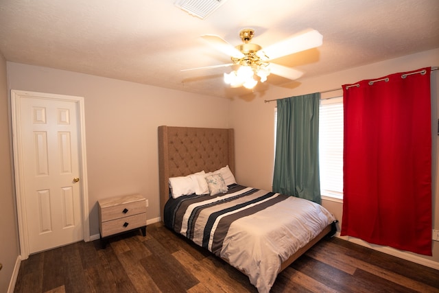 bedroom featuring a textured ceiling, ceiling fan, and dark hardwood / wood-style flooring