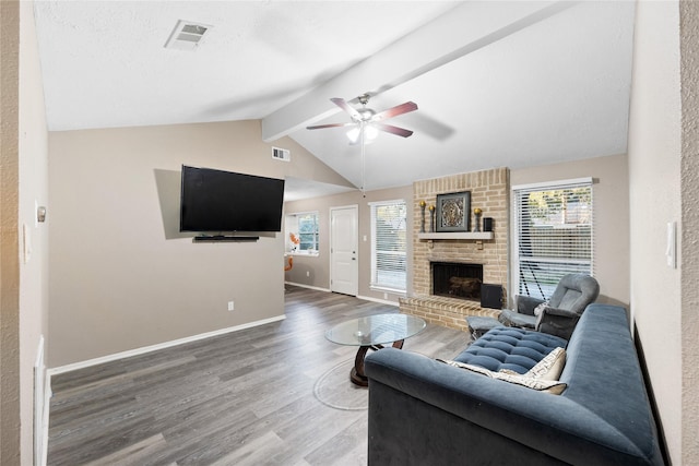 living room with vaulted ceiling with beams, ceiling fan, wood-type flooring, and a fireplace