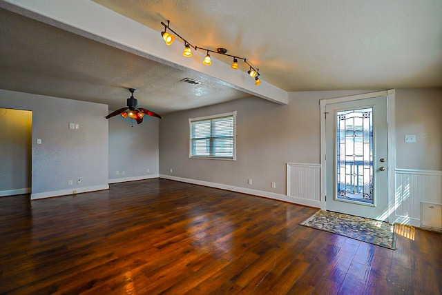 entryway with dark wood-type flooring, ceiling fan, lofted ceiling with beams, and a textured ceiling