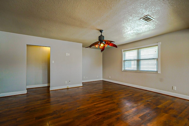 empty room with a textured ceiling, dark wood-type flooring, and ceiling fan