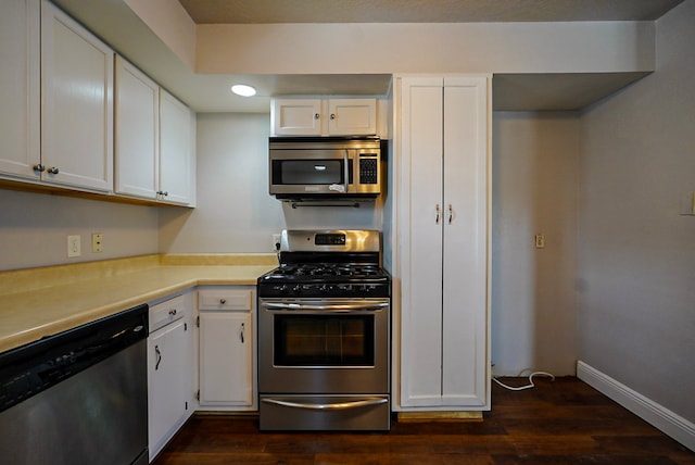 kitchen featuring appliances with stainless steel finishes, dark hardwood / wood-style flooring, and white cabinets