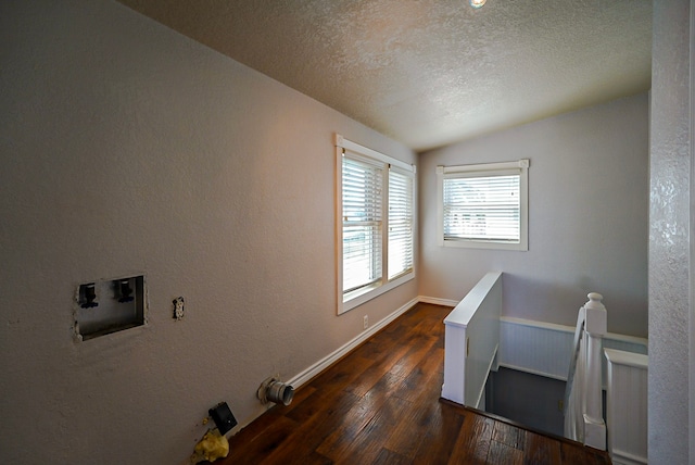 clothes washing area with hookup for a washing machine, a textured ceiling, and dark hardwood / wood-style flooring