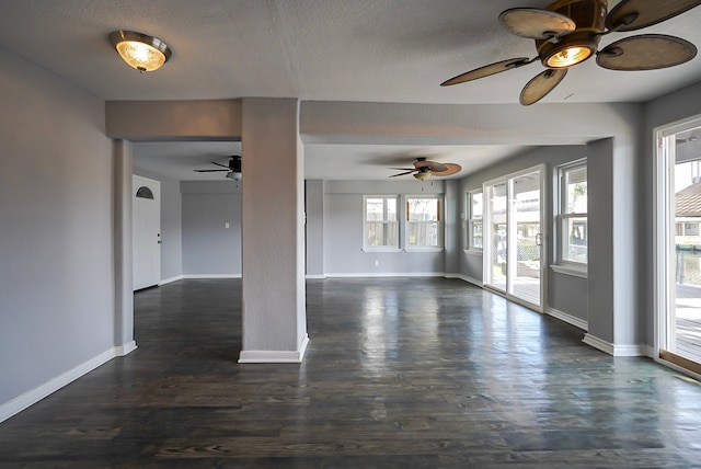 spare room with a wealth of natural light, ceiling fan, a textured ceiling, and dark hardwood / wood-style flooring