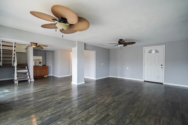 unfurnished living room with ceiling fan and dark hardwood / wood-style flooring