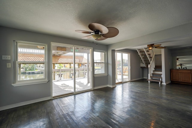 interior space featuring a textured ceiling, ceiling fan, and dark hardwood / wood-style flooring