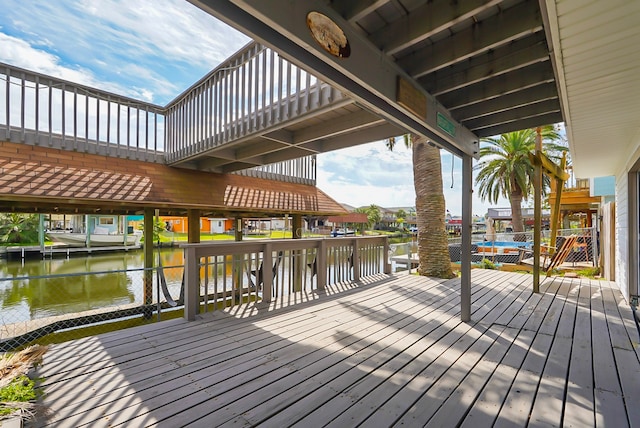 wooden terrace featuring a dock and a water view