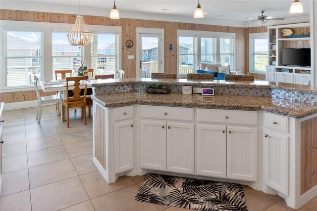 kitchen featuring a wealth of natural light, light tile patterned floors, white cabinets, and open floor plan