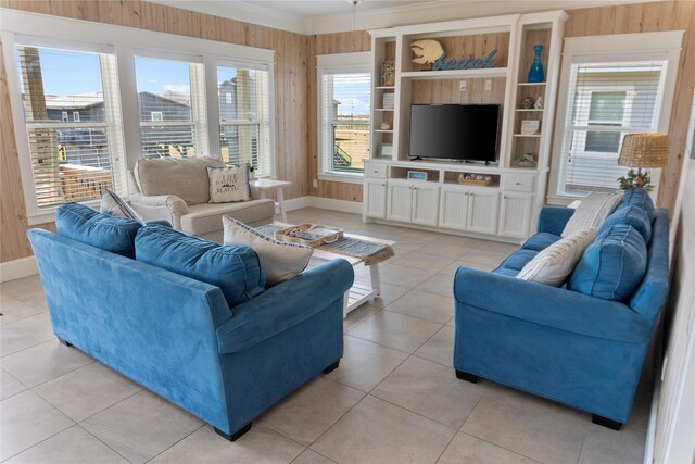 living room featuring a healthy amount of sunlight, wooden walls, and light tile patterned floors