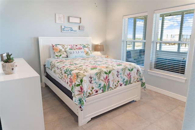 bedroom featuring light tile patterned floors and baseboards