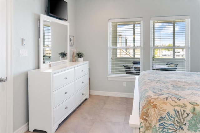 bedroom with light tile patterned floors and baseboards