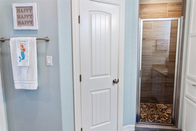 bathroom featuring a shower with door