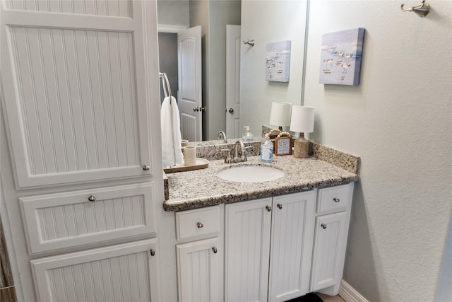 bathroom featuring vanity and a textured wall