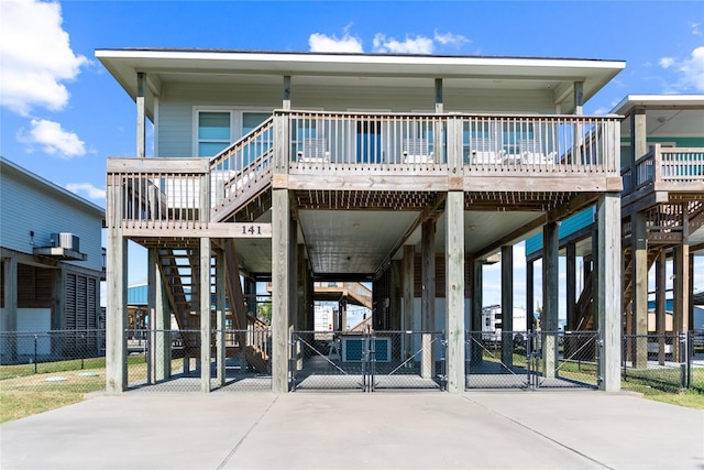 exterior space featuring a gate, fence, driveway, stairs, and a carport