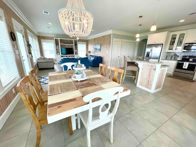 dining area with light tile patterned floors, visible vents, a chandelier, and crown molding