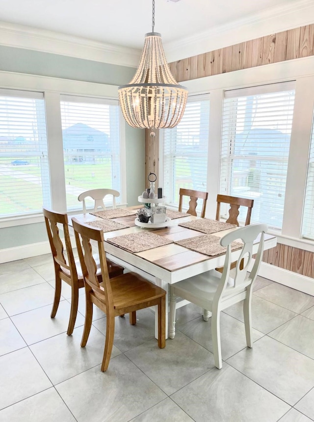 dining area with light tile patterned floors, a healthy amount of sunlight, baseboards, and ornamental molding