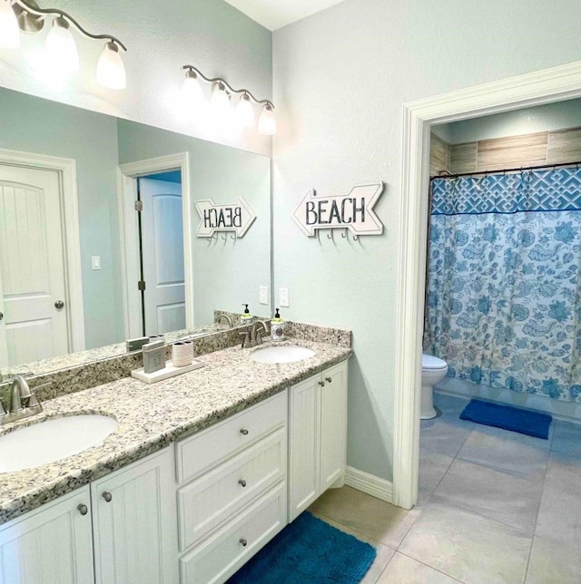 bathroom with tile patterned flooring, double vanity, toilet, and a sink