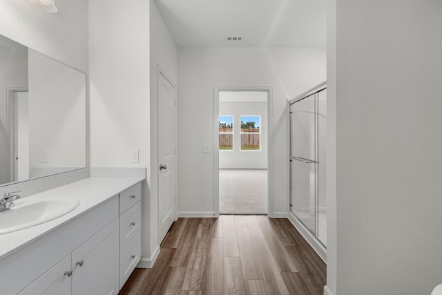 bathroom featuring a stall shower, visible vents, vanity, and wood finished floors