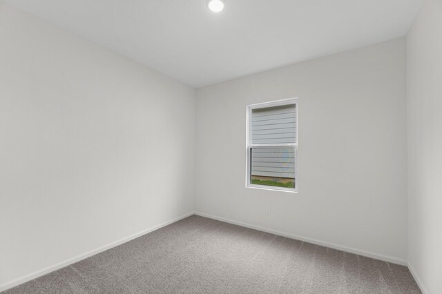 unfurnished room featuring carpet flooring and baseboards