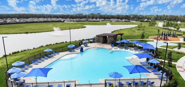 community pool featuring a patio area, a residential view, fence, and a yard