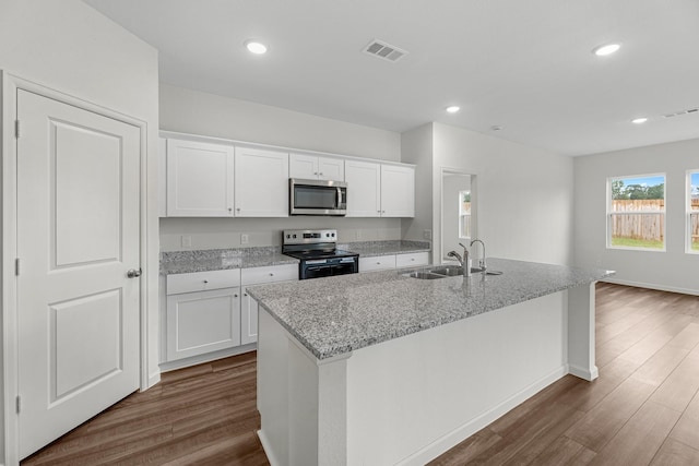 kitchen featuring white cabinets, a kitchen island with sink, stainless steel appliances, and sink