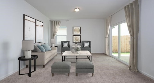 living area featuring light carpet, plenty of natural light, and baseboards