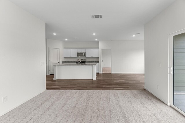 kitchen featuring recessed lighting, stainless steel appliances, visible vents, white cabinetry, and open floor plan