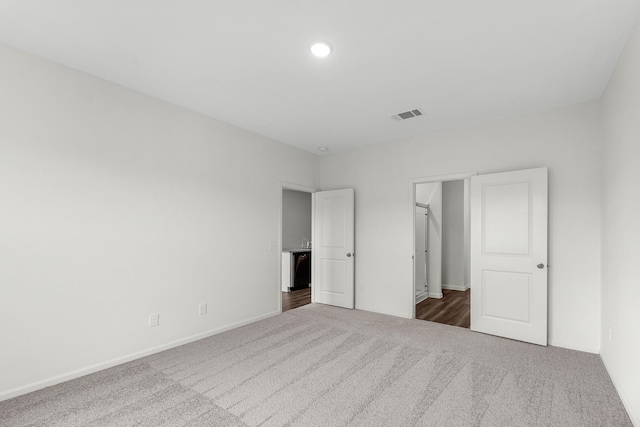 unfurnished bedroom with carpet floors, baseboards, and visible vents