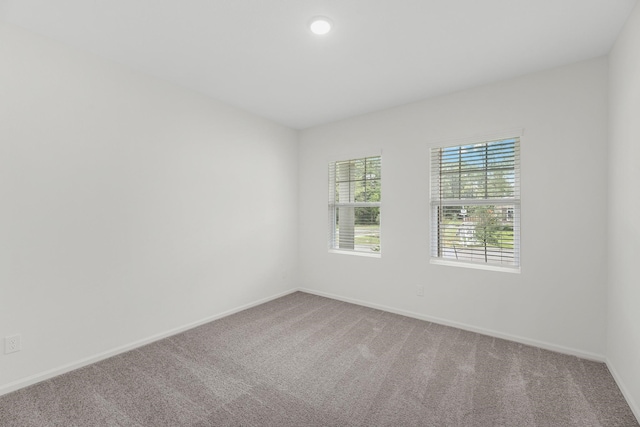 carpeted empty room featuring baseboards