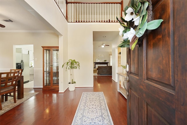 entrance foyer with ceiling fan, wood finished floors, visible vents, and ornamental molding