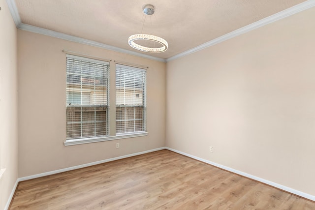 spare room with ornamental molding and light hardwood / wood-style floors