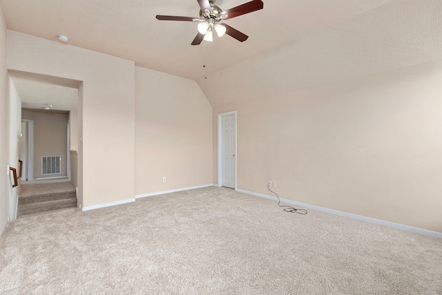 carpeted spare room with ceiling fan and vaulted ceiling