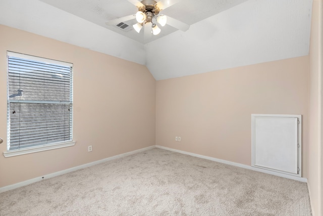 empty room featuring lofted ceiling, light colored carpet, and ceiling fan