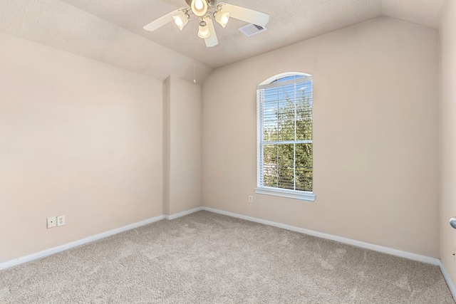 carpeted empty room with a textured ceiling and vaulted ceiling