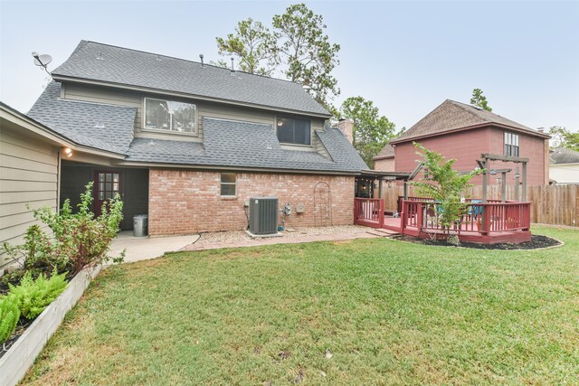 back of house featuring a wooden deck, a patio, a yard, and central air condition unit