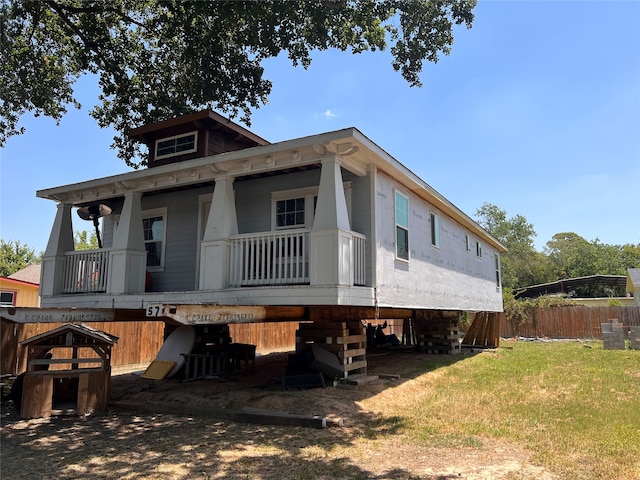 rear view of house with a yard and a balcony