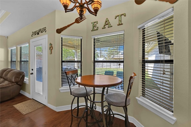 dining room with a wealth of natural light, dark wood-type flooring, and a chandelier