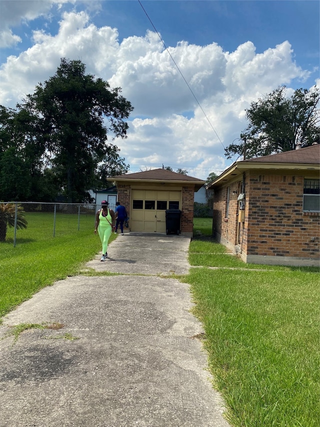 view of front of house featuring a front lawn, a garage, and an outbuilding